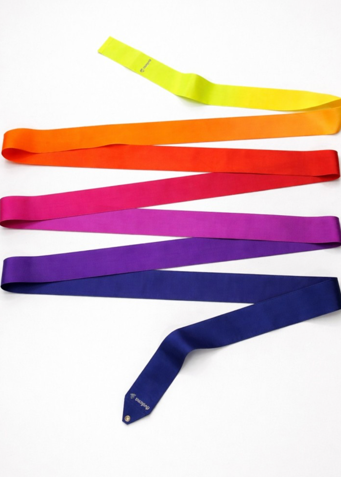 Wstążka do gimnastyki artystycznej Navy Blue Orange w kolorach: żółtym, czerwonym, fuksji, fioletowym, granatowym; ułożona w zygzak na jasnym tle.